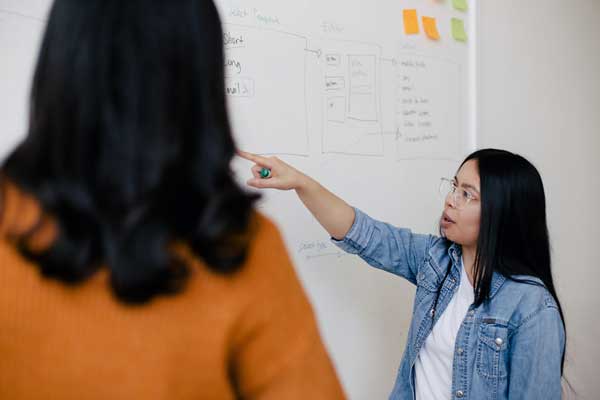 Woman pointing at whiteboard